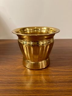 a golden bowl sitting on top of a wooden table