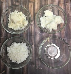 four glass bowls filled with food on top of a wooden table