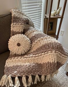 a brown and white blanket sitting on top of a couch