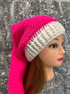 a doll wearing a pink and white knitted hat