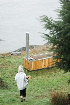 a person standing in front of a hot tub on top of a grass covered field