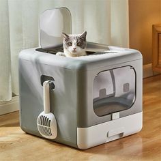 a cat sitting on top of a grey and white litter box