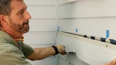 a man is painting the side of a house