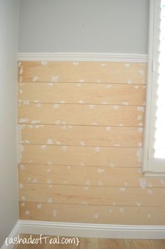 an empty room with white paint on the walls and wood flooring that has been stripped off