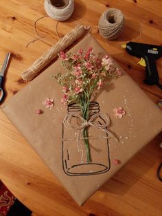 a table topped with crafting supplies and flowers on top of a piece of paper