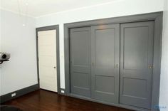 an empty room with three doors and a camera mounted on the wall next to it