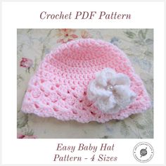 a crochet baby hat with a flower on the front and side, in pink