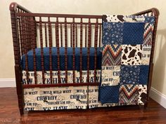 a baby crib with a cow theme and blue blankets on it's sides