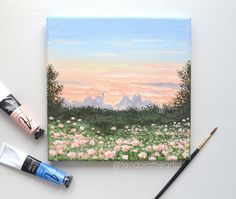 a painting with watercolors and paintbrushes next to it