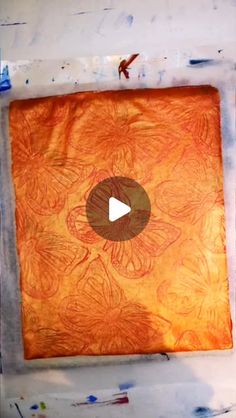 an orange piece of art with a video playing on it