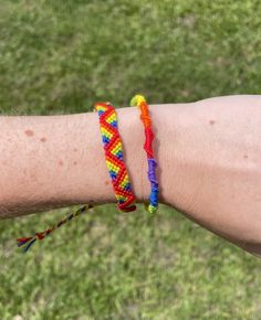 a person's arm with two different colored bracelets on it, one is holding the other