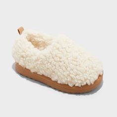 Keep your toddler's feet comfy and cozy with these Faux-Shearling Clog Slippers from Cat & Jack™. Designed in a soft beige hue, these slippers are made from plush faux-shearling fabric with a cushioned footbed for all-day comfort. A closed-toe upper with a covered back, slip-on style with a back pull tab and an indoor/outdoor outsole for all-purpose wear complete the design. Cat & Jack™: Designed for all children so you can trust it's made for yours. Shearling Slippers With Faux Fur Lining And Round Toe, Soft Sheepskin Slippers With Round Toe, Beige Slippers, Beige Non-slip Indoor Slippers, Shearling Slip-on Slippers With Textured Footbed, Cozy Slip-on Slippers With Faux Fur Lining, Construction For Kids, Suede Clogs, Glitter Boots