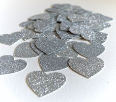 silver glitter hearts are arranged on a white background