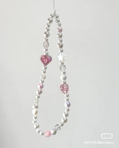 a necklace with hearts and pearls hanging from it