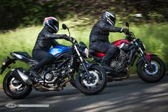 two motorcyclists are riding down the road in their helmets and leather jackets