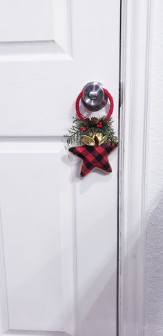 This charming door decor is a fantastic way to help bring that feeling of Christmas into your entryway, your home or office. This Door Charm is made with  a fabric covered red and black buffalo plaid star that is trimmed with jute cord, the handle is wrapped with red ribbon. It is embellished with golden bells, pine shrubs, pine cones and berries.  This decor will be perfect for door knob decorations. This will make a perfect addition to your holiday decorations. Christmas Door Knobs, Holiday Door Knob Hangers, Black Door Decor, Christmas Door Knob Hangers, Winter Door Hanger, Door Decor Christmas, Door Knob Hanger, Doorknob Hangers, Winter Door