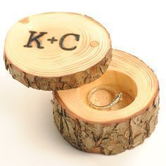 two wooden slices with the initials k and c on them, one has a wedding ring in it