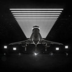 a large jetliner sitting on top of an airport tarmac under a light filled ceiling