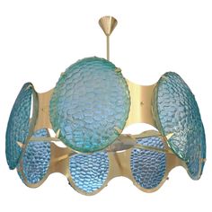 a chandelier with blue glass shades hanging from the ceiling