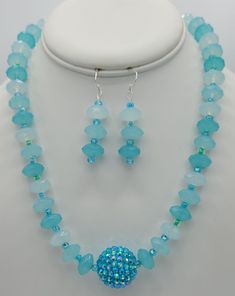 The 19 inch necklace is made with a sparkly round baby blue specialty bead in the center (1  inch circumference).  The rest of the necklace is made with matching round quartz beads and seed beads.  The closure on the necklace is a sterling silver toggle clasp.  Matching earrings are made with round quartz beads and the seed beads.  The earrings hang a total of 2 inches and have a sterling silver earring wire. Adjustable Faceted Blue Crystal Necklace, Blue Faceted Round Bead Crystal Necklace, Blue Faceted Crystal Necklace With Round Beads, Light Blue Gemstone Beads For Jewelry Making, Adjustable Light Blue Jewelry With Spacer Beads, Blue Sterling Silver Necklace With Spacer Beads, Blue Sterling Silver Beaded Necklace With Faceted Beads, Blue Crystal Jewelry With Gemstone Beads, Blue Beaded Round Pendant Jewelry