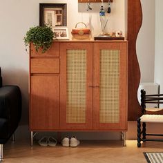 a living room with a black chair and wooden cabinet