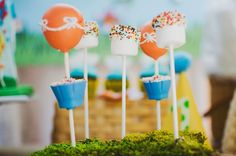 cake pops with sprinkles on them are sitting in the middle of a table