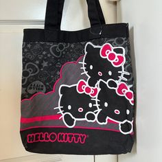 a black hello kitty bag hanging on a door with the word hello kitty printed on it