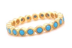 a gold and turquoise colored ring with blue stones on the inside, set against a white background