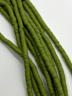 green beans are arranged on a white surface