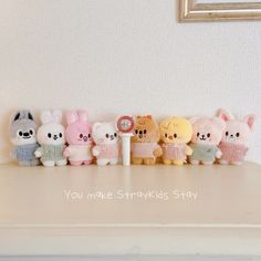 a row of small stuffed animals sitting on top of a white counter next to a mirror