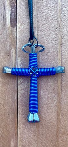 a blue cross hanging from the side of a wooden wall