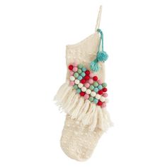 a christmas stocking with beads and tassels hanging from it's side