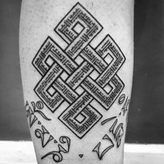 a black and white photo of a man's leg with an intricate tattoo design on it