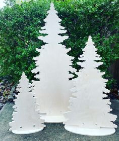 two white wooden christmas trees sitting next to each other