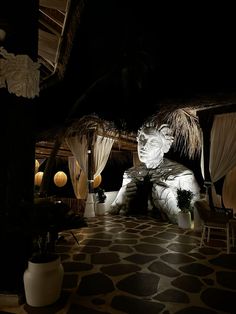 a large statue is in the middle of a room with lights and curtains on it