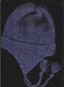 a blue knitted hat with a tassel on the side and a black background