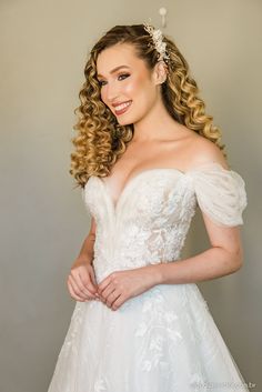 a woman in a wedding dress posing for the camera with her hands on her hips