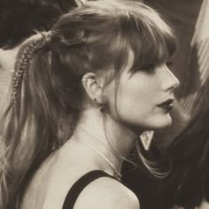 a black and white photo of a woman with her hair in a pony tail braid