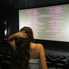 a woman standing in front of a projection screen with her hair blowing in the wind