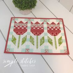 a potted plant sitting on top of a table next to a quilted place mat