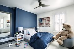 a teddy bear sitting on top of a bed in a bedroom