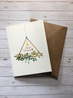 two christmas cards, one with a triangle and the other with an ornament on it