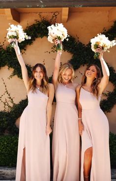 three bridesmaids holding bouquets in their hands