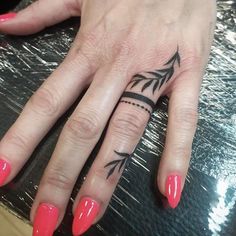 a woman's hand with a tattoo on it and a red manicured nail