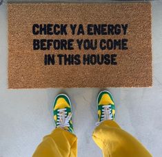 someone standing in front of a door mat that says check va energy before you come in this house