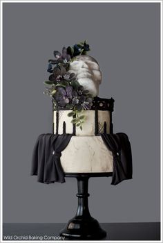 a white and black cake with flowers on top