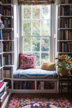 a window seat in front of a bookshelf filled with lots of books and flowers