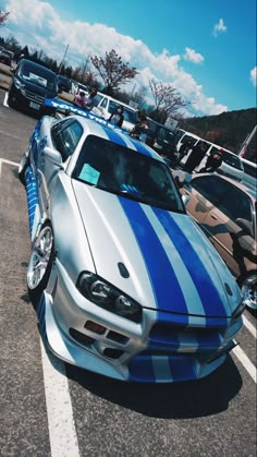 a silver and blue car parked in a parking lot