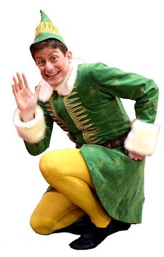 a man dressed in green and yellow is posing for the camera with his hands out