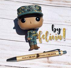 a pop vinyl figure is posed next to a fountain pen on a wooden background with the words by fiction written below it